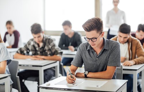Schülerinnen und Schüler schreiben konzentriert eine Klassenarbeit im Prüfungsraum