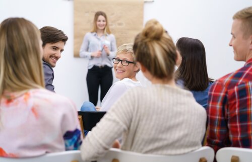 Gruppe von Teilnehmenden hört einem Vortrag in einem Seminarraum