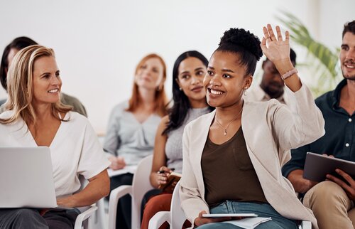 Teilnehmende in Seminar stellen Fragen und diskutieren aktiv im Gruppenraum
