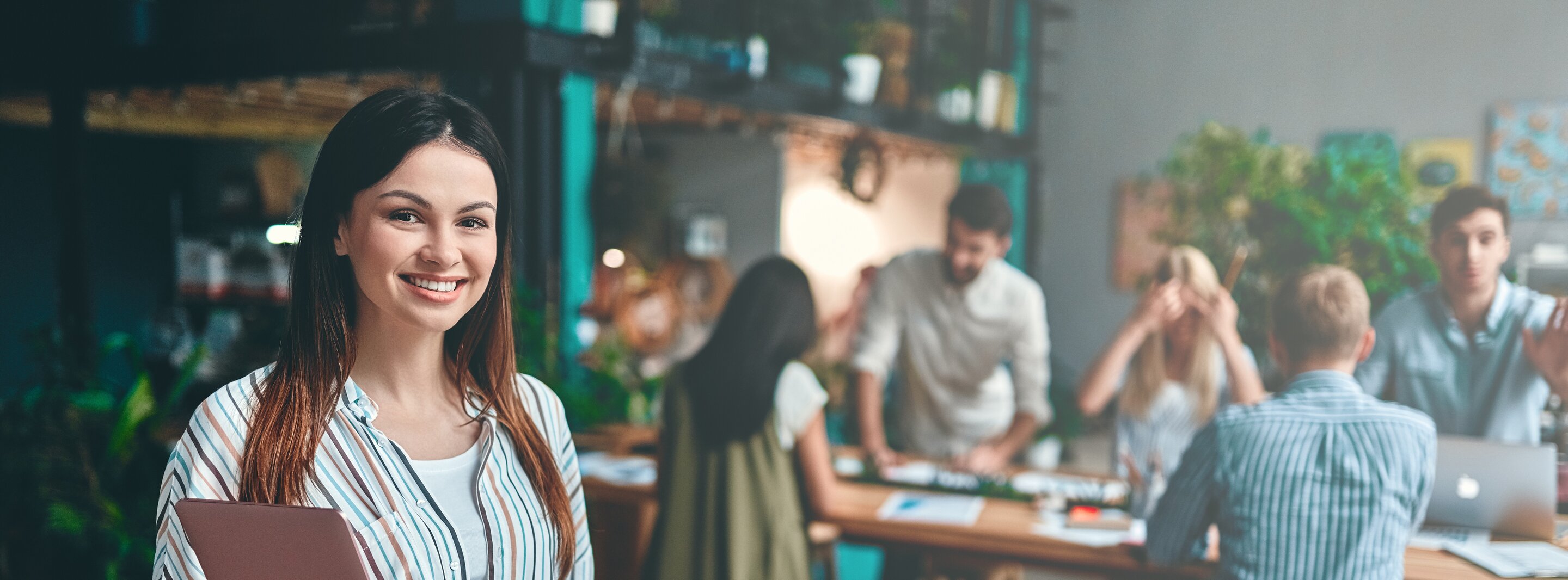 Podcast der IHK Akademie München - junge Frau steht im Vordergrund und lächelt in die Kamera