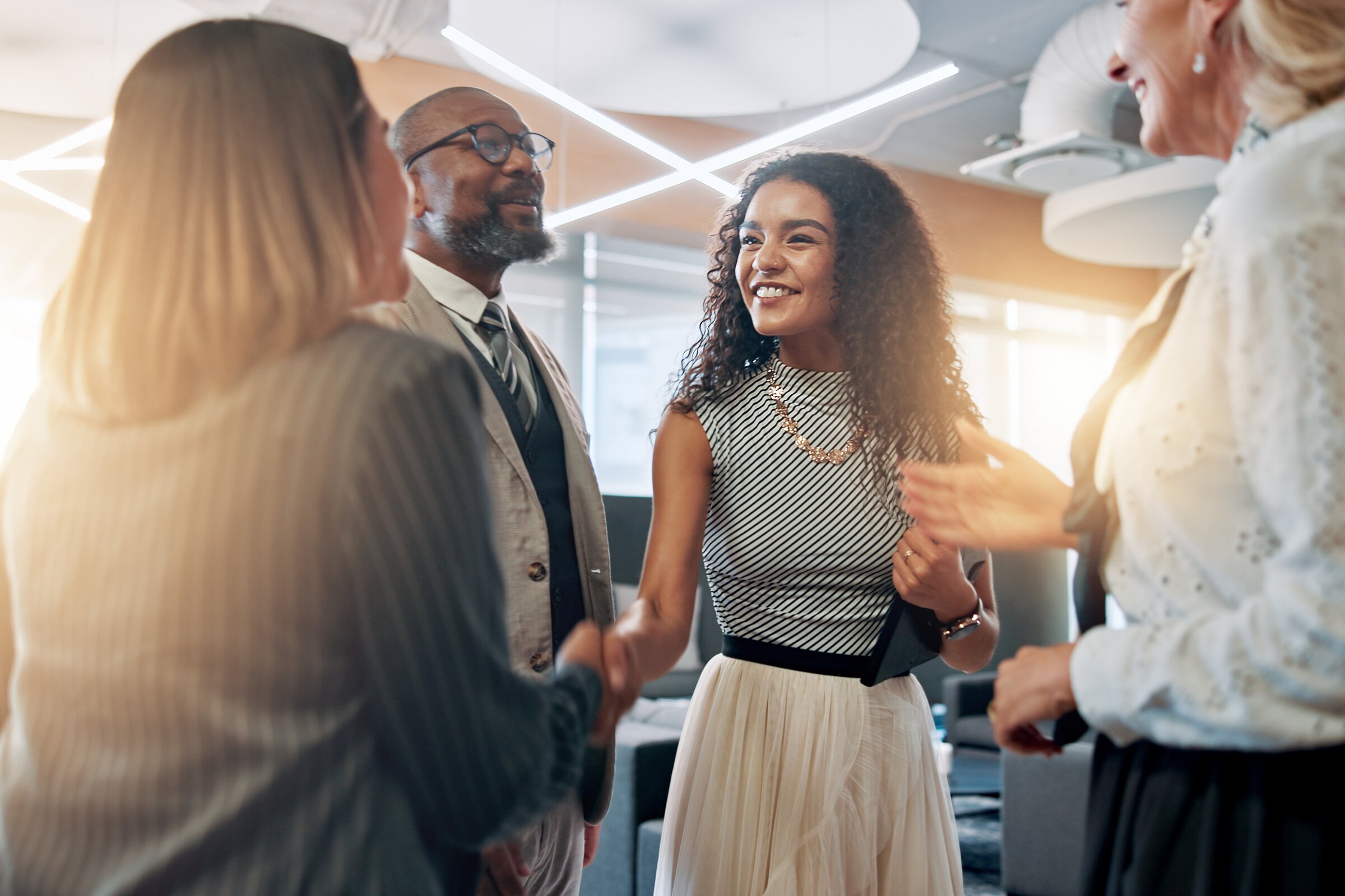 Mitarbeitende im Gespräch in heller Büroumgebung – steht für die enge regionale Vernetzung der IHK Akademie München und Oberbayern mit Unternehmen und Partner/-innen in der Wirtschaft.