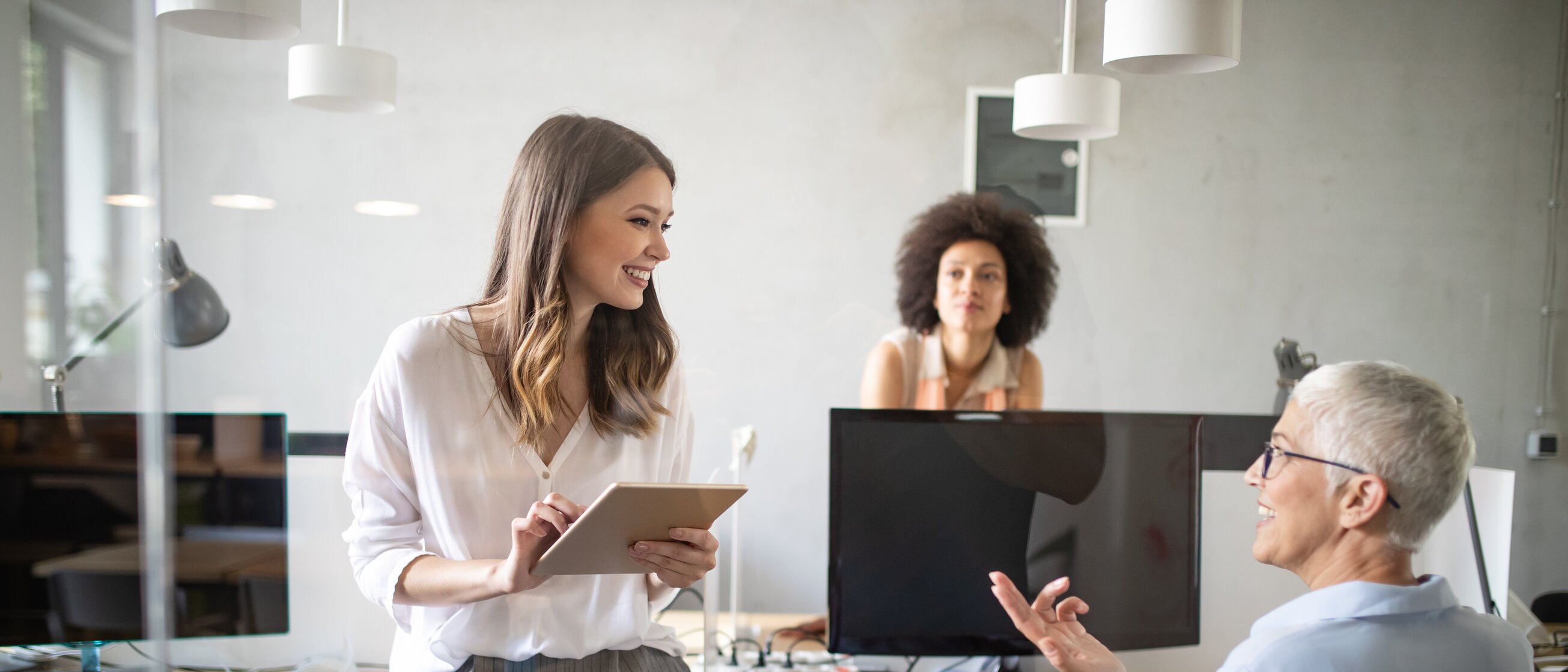 Beraterin bespricht individuelle Weiterbildungsberatung mit Unternehmerin und Privatkundin im modernen Büro.
