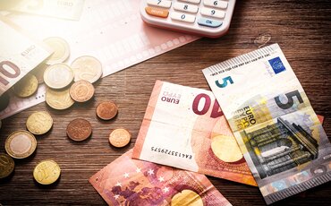 Euro-Münzen, Geldscheine und Taschenrechner – Symbol für finanzielle Fördermöglichkeiten bei Weiterbildungen