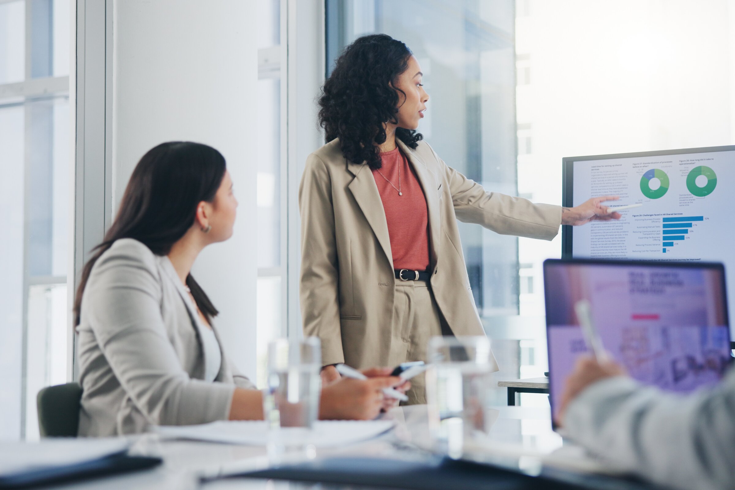 Dozentin erklärt Präsentation im Meetingraum – Inhouse-Schulung für Unternehmen