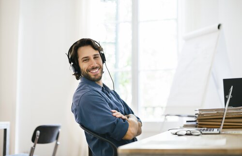 Teilnehmer mit Laptop und Headset im Arbeitsumfeld – Blended-Learning-Konzept der IHK Akademie München kombiniert Online-Selbstlernphasen und Präsenzphasen für nachhaltigen Lernerfolg.