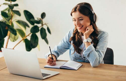 Teilnehmerin nimmt mit Headset an einem Live-Online-Lehrgang der IHK Akademie München teil – interaktives Lernen im virtuellen Klassenzimmer mit direktem Austausch.