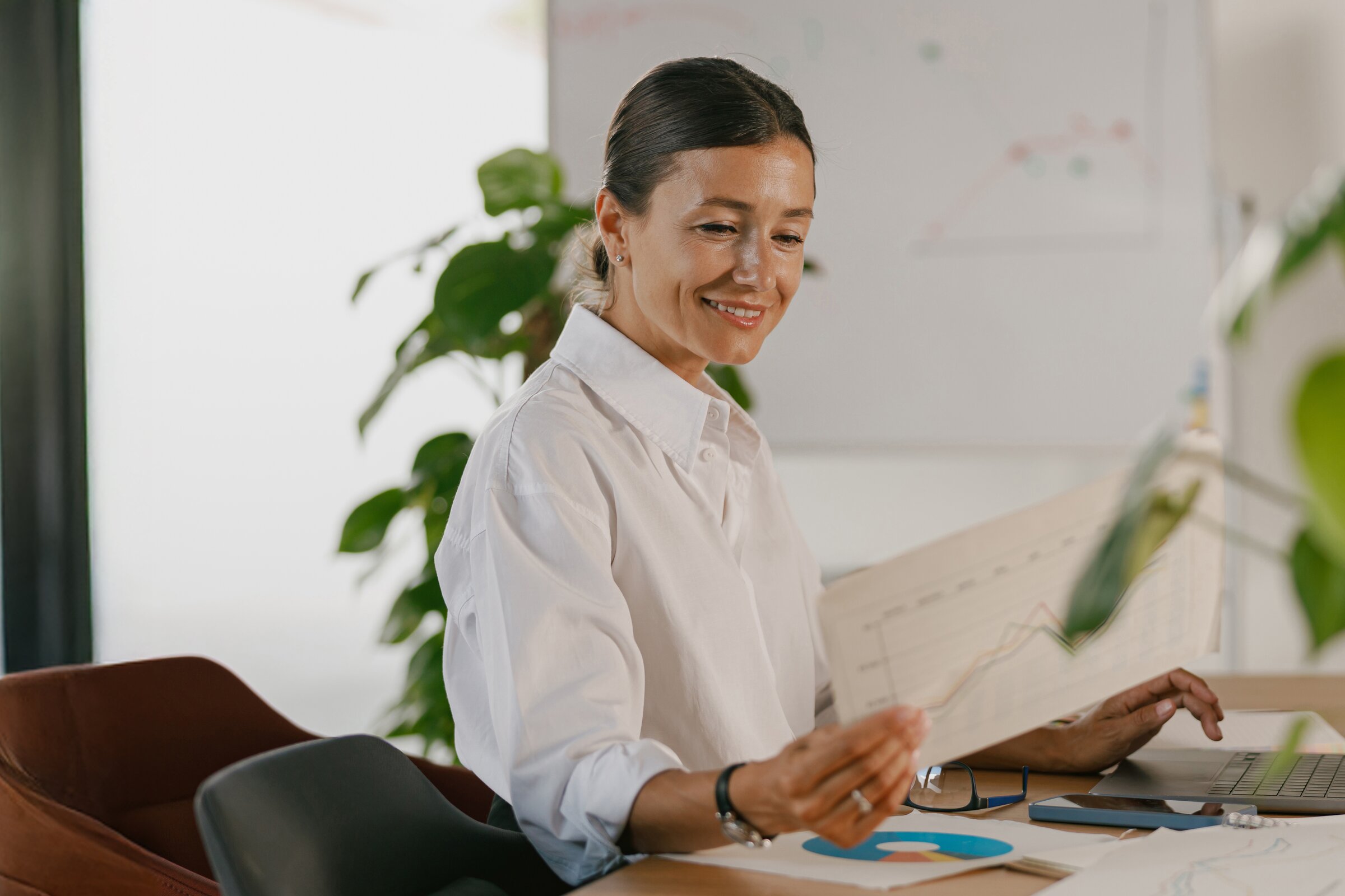 Eine vierköpfige Gruppe hält einen kreativen Workshop vor einer Glaswand voller bunter Haftnotizen.