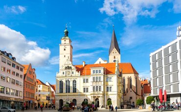 Gruppe von TeilnehmeGruppe von Menschen steht auf einer hölzernen Plattform zwischen hohen Bäumen – Teamtraining auf der Westerhamer Teamplattform mit Blick ins Talnden steht auf der hölzernen Teamplattform im Westerhamer Akademiewald