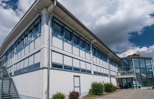 Modernes Akademiegebäude der IHK Akademie Mühldorf an der Töginger Straße bei sonnigem Wetter