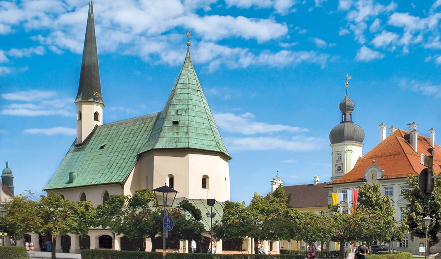 historische stadtpfarrkirche mit grünem dach und barocken türmen in mühldorf am inn