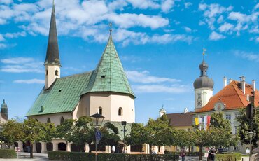 Gruppe von TeilnehmeGruppe von Menschen steht auf einer hölzernen Plattform zwischen hohen Bäumen – Teamtraining auf der Westerhamer Teamplattform mit Blick ins Talnden steht auf der hölzernen Teamplattform im Westerhamer Akademiewald