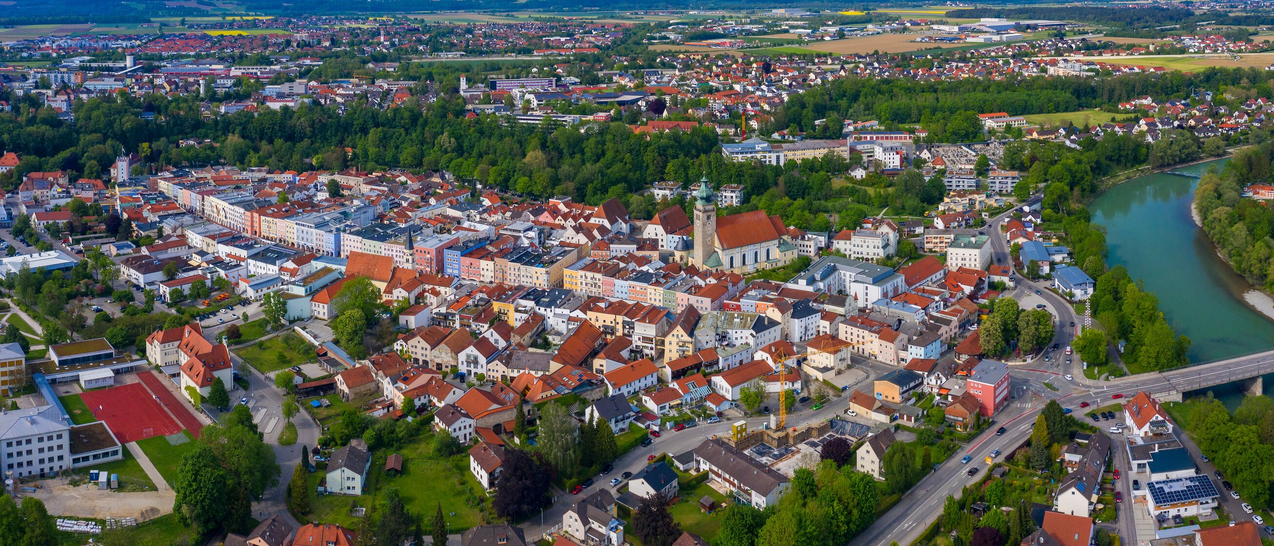 Luftaufnahme der Stadt Mühldorf am Inn mit Kirche und Fluss – Standort der IHK Akademie Mühldorf in der Region Inn-Salzach.