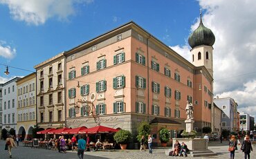 Gruppe von TeilnehmeGruppe von Menschen steht auf einer hölzernen Plattform zwischen hohen Bäumen – Teamtraining auf der Westerhamer Teamplattform mit Blick ins Talnden steht auf der hölzernen Teamplattform im Westerhamer Akademiewald