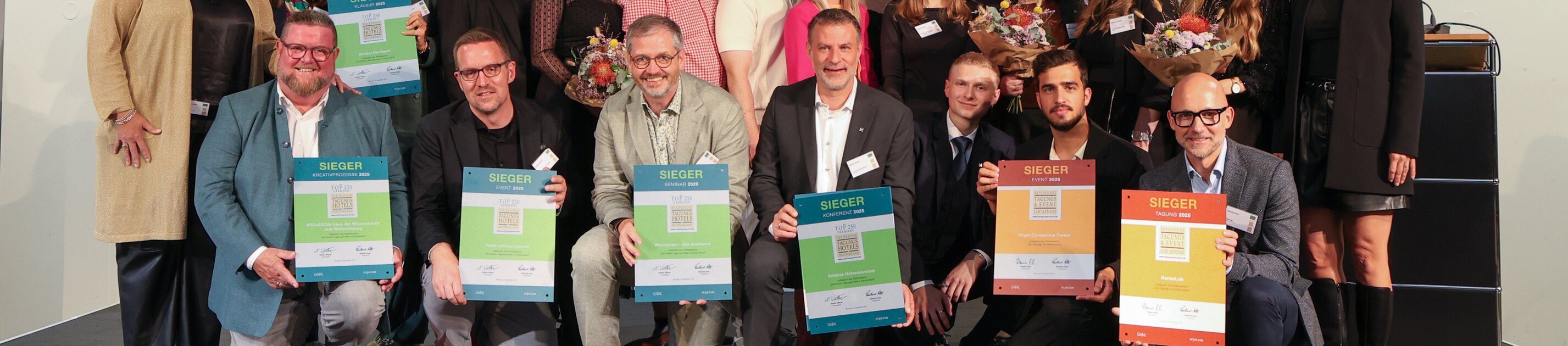 Gruppenfoto der Preisträger bei der Auszeichnung der Top 250 Tagungshotels Deutschland 2025/2026 – Siegerteams halten ihre Urkunden auf der Bühne
