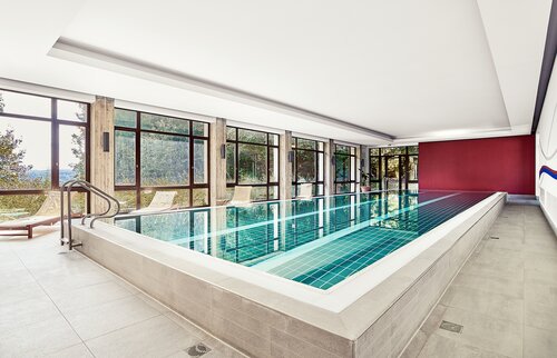 Modernes, lichtdurchflutetes Hallenbad der Akademie Westerham mit großen Panoramafenstern und Blick ins Grüne