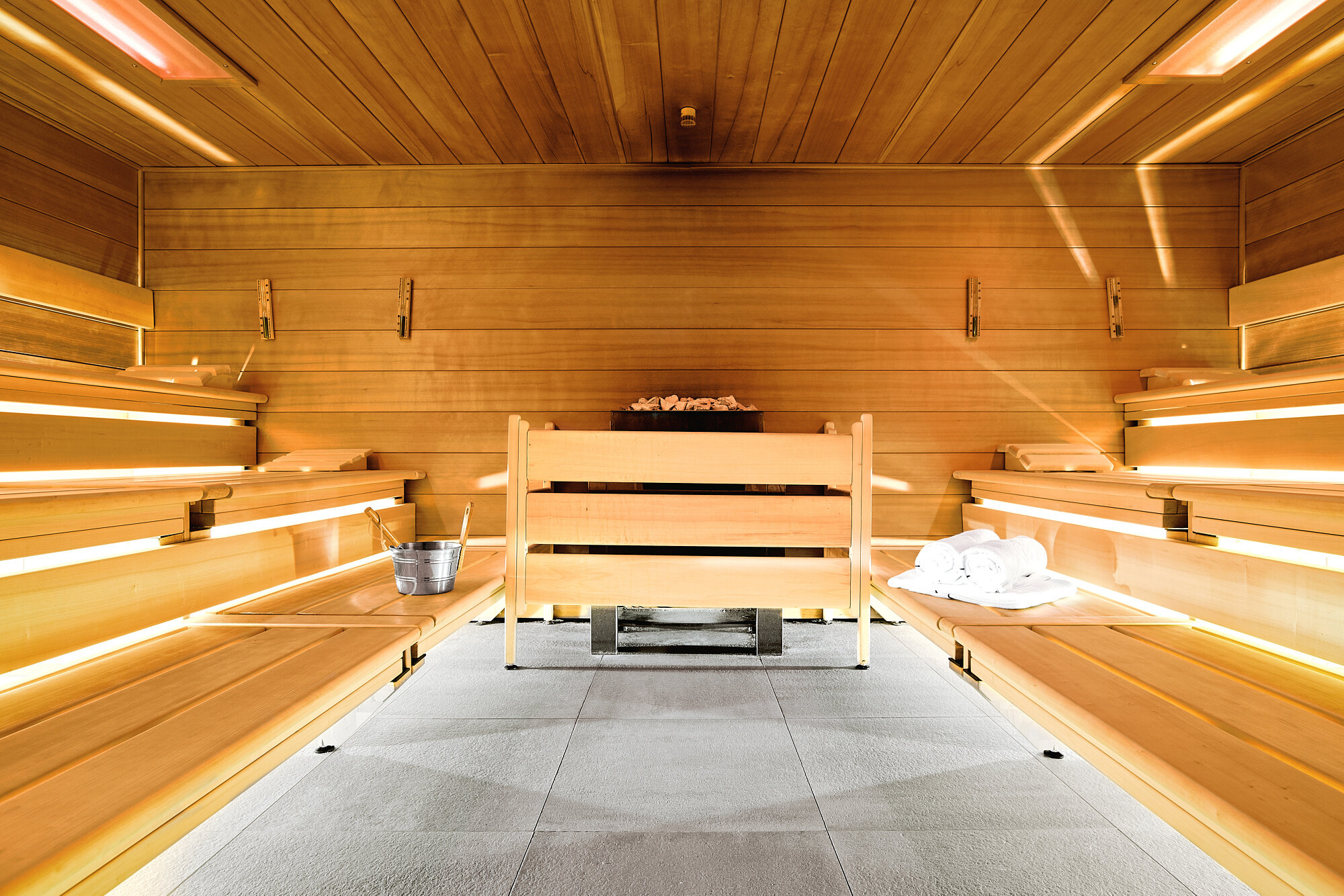 Sauna der Akademie Westerham mit Holzverkleidung, Bänken und Handtüchern – ein warmer Rückzugsort zur Entspannung nach Seminaren