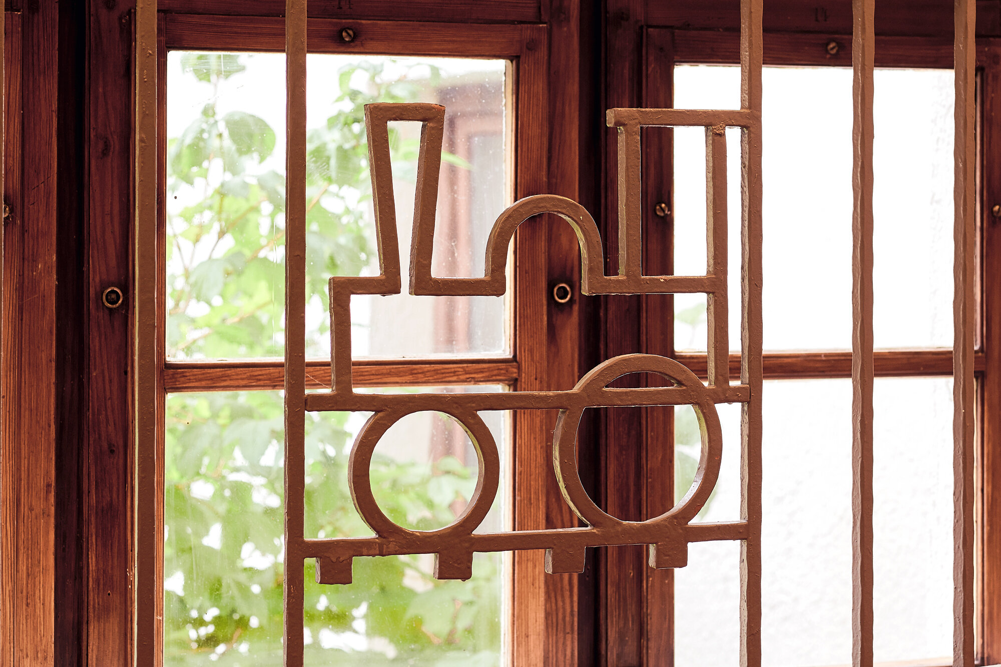 Holzornament in Form einer stilisierten Dampflokomotive als Fensterverzierung in der IHK Akademie Westerham, inspiriert von der Geschichte des Hauses als Erholungsheim der Reichsbahn.