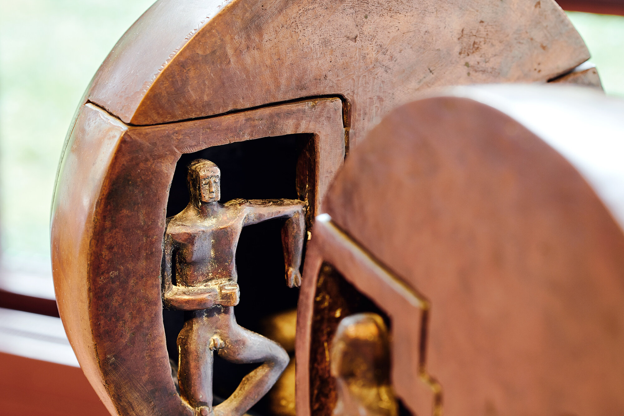 Bronzeskulptur in der IHK Akademie Westerham mit plastischer Darstellung einer menschlichen Figur in Bewegung, eingearbeitet in eine kreisförmige Form – ein Kunstwerk mit Bezug zur handwerklichen Tradition des Hauses.