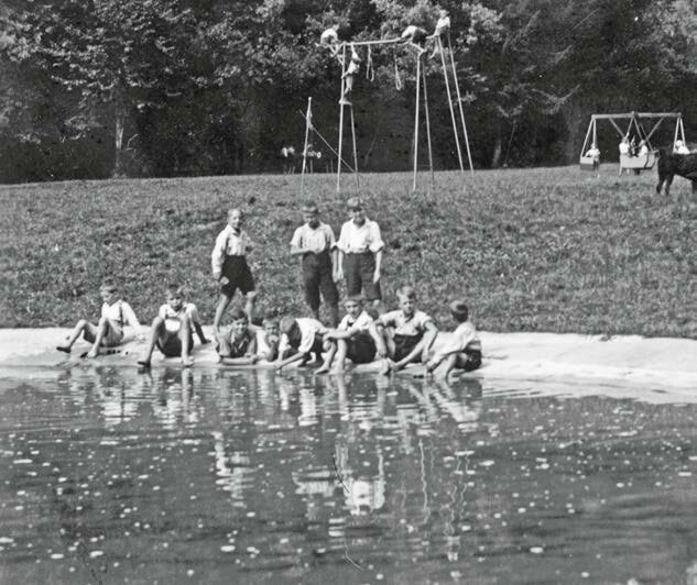 Historische Schwarz-Weiß-Aufnahme von Kindern am Wasserbecken des Kinderkurheims Westerham beim Spielen und Abkühlen im Sommer