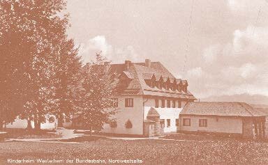 Historische Außenansicht des ehemaligen Kinderkurheims in Westerham, umgeben von Bäumen, aufgenommen in den 1960er Jahren – das Gebäude, das später zur IHK Akademie Westerham wurde.