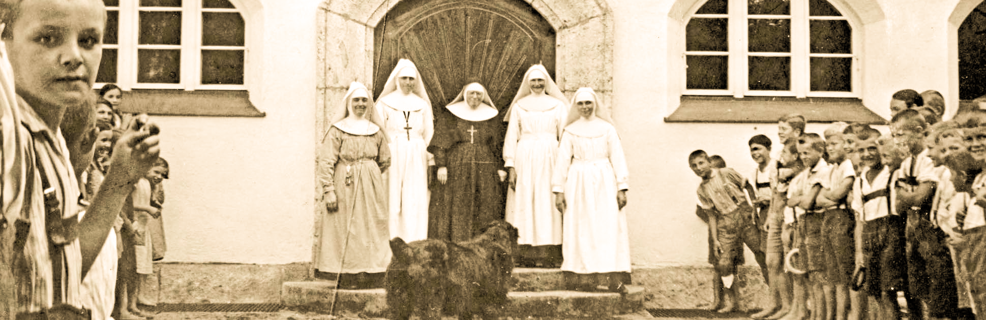 Historische Szene mit Nonnen Kindern und Hund vor Gebäude mit Rundbogenportal