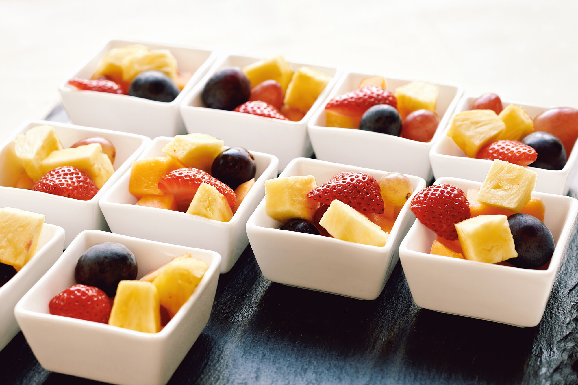 Frische Obstsalate mit Erdbeeren, Ananas und Blaubeeren beim Frühstücksbuffet der Akademie Westerham für einen energiegeladenen Start in den Tag