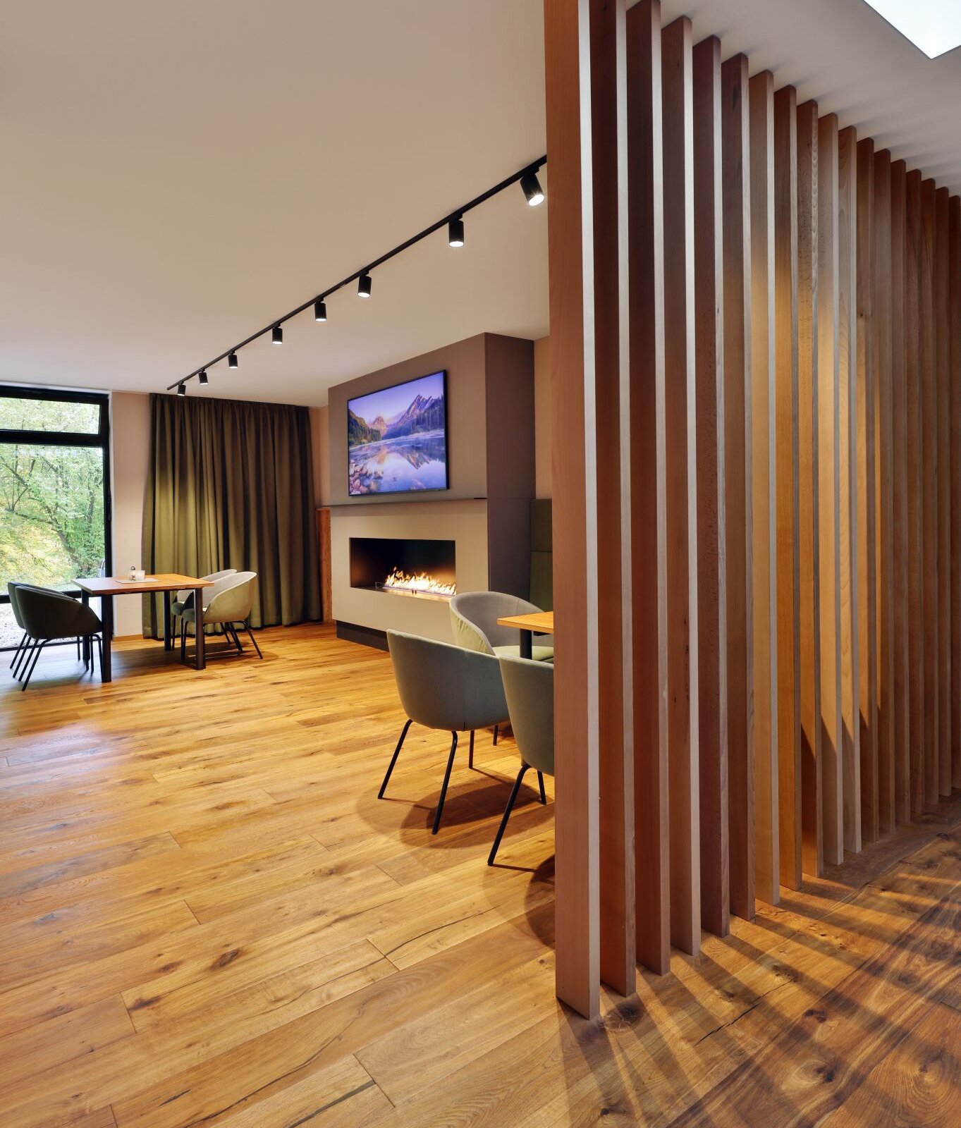 Moderner Tagungsraum der Akademie Westerham mit Holzelementen, Kamin und warmem Lichtambiente