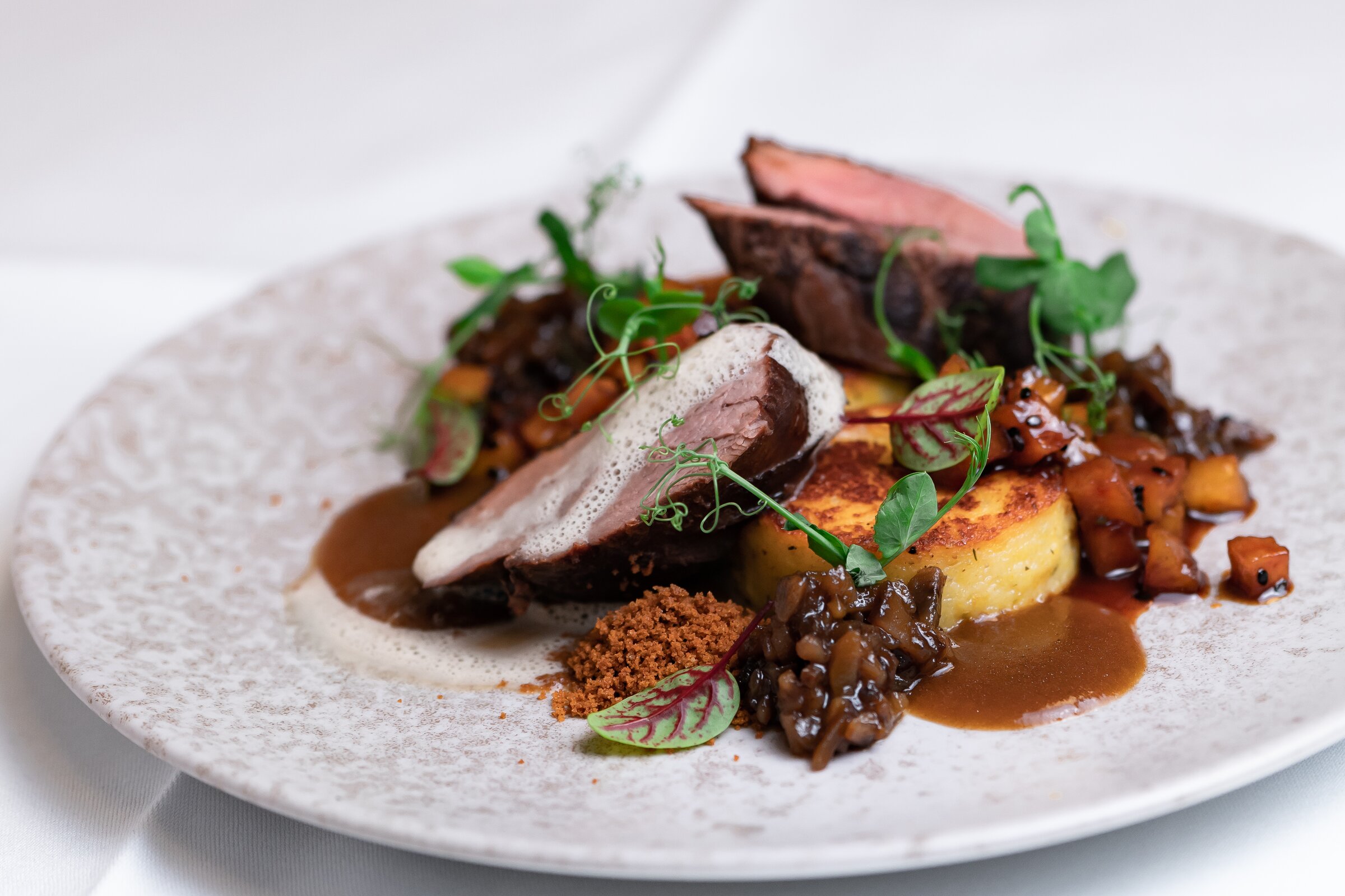 Fein angerichtetes Hauptgericht mit Fleisch, Gemüse und Sauce aus der Küche der Akademie Westerham