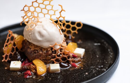 Fein angerichtetes Dessert mit Eis, Honig-Dekor und Früchten aus dem Menüangebot der Akademie Westerham