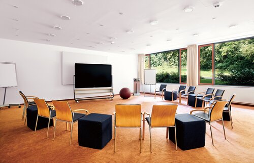 Moderner Seminarraum in der Akademie Westerham mit Stuhlkreis und Blick ins Grüne für Workshops und Tagungen