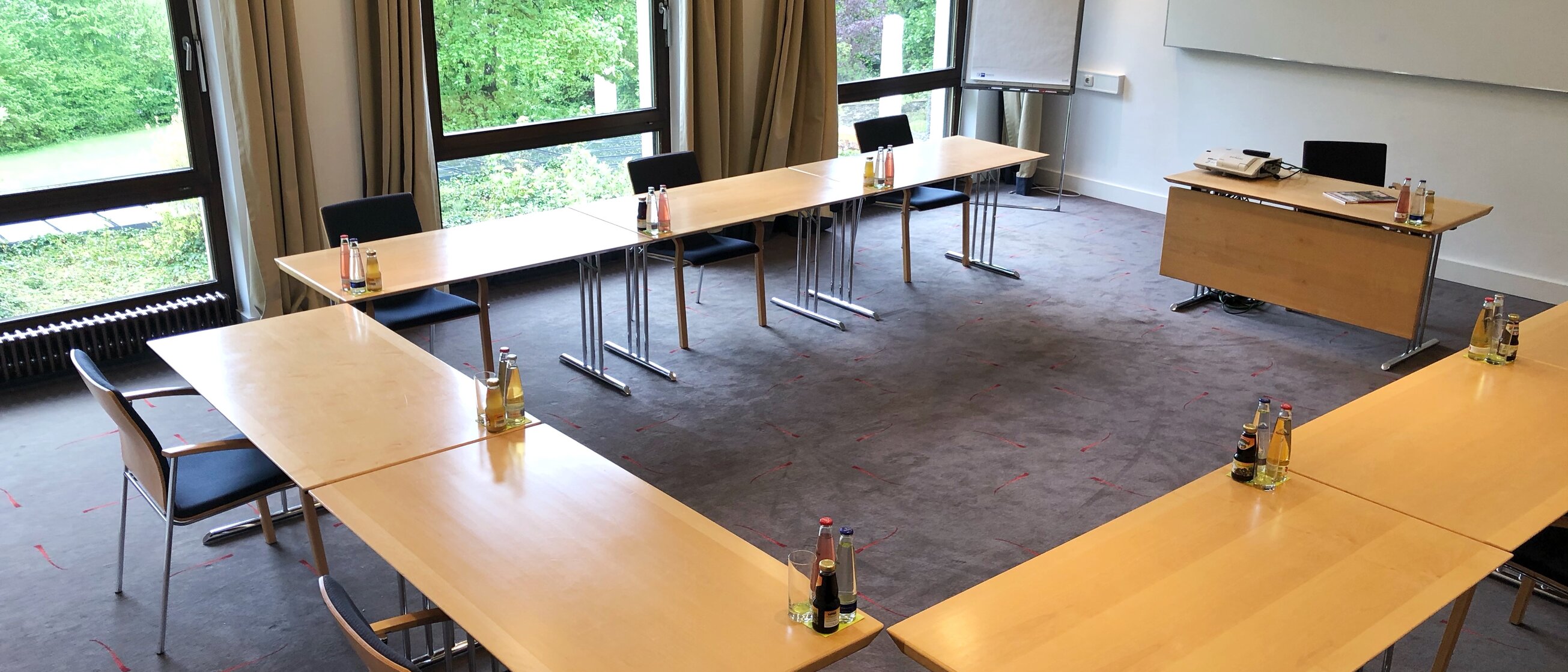 Seminarraum in der Akademie Westerham mit U-förmiger Tischanordnung, Tageslicht und Blick ins Grüne für Tagungen und Workshops