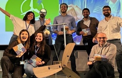 Team aus acht Personen präsentiert stolz ein selbstgebautes Windrad beim Westerhamer Windfarm Teambuilding