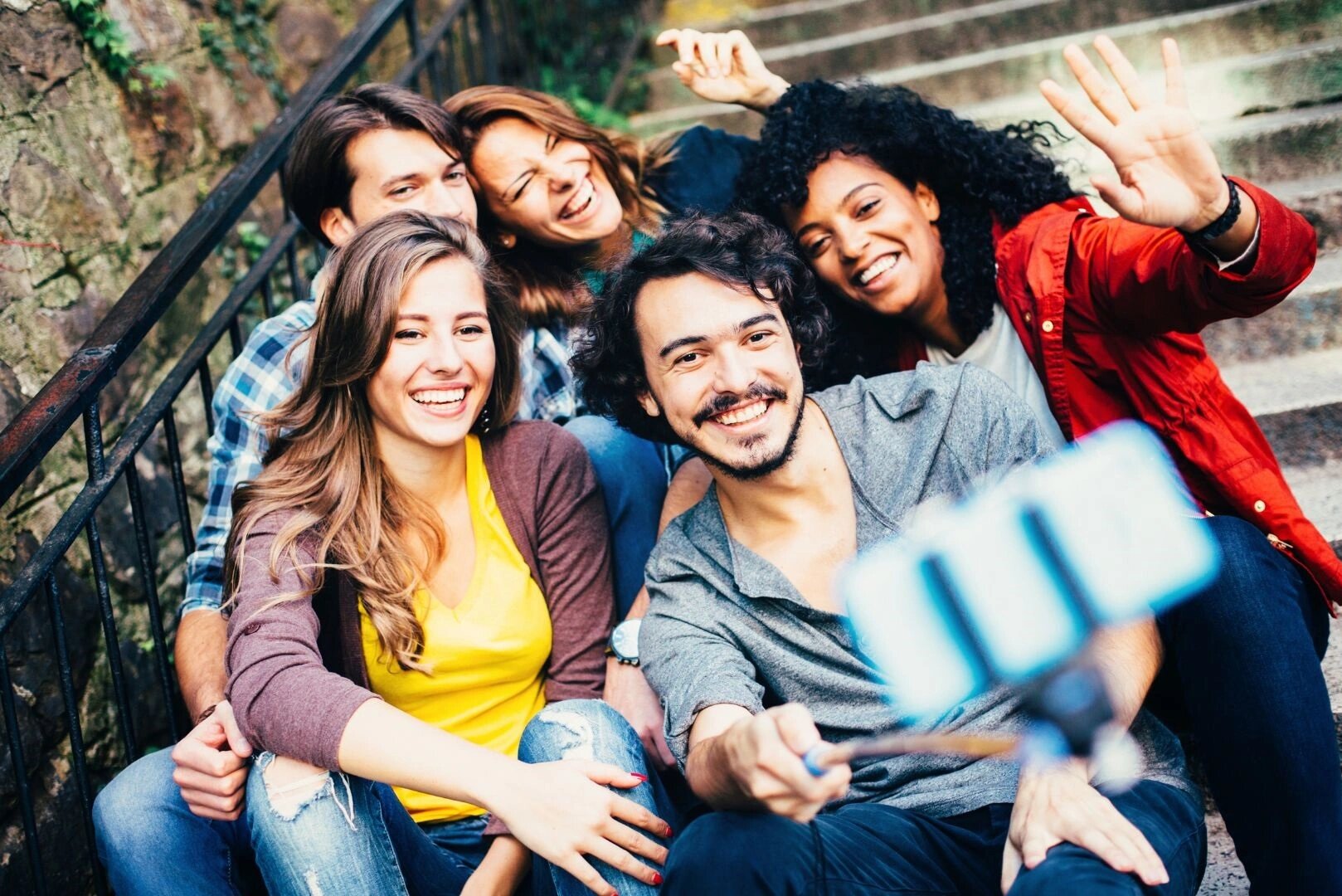 Gruppe junger Menschen sitzt fröhlich zusammen und macht ein Selfie mit dem Smartphone – Symbolbild für die Indoor-Smartphone-Rallye in der IHK Akademie Westerham