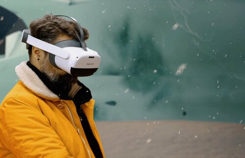 Mann mit Virtual-Reality-Brille erlebt digitales Teamevent – interaktive virtuelle Teamerlebnisse für moderne Unternehmen