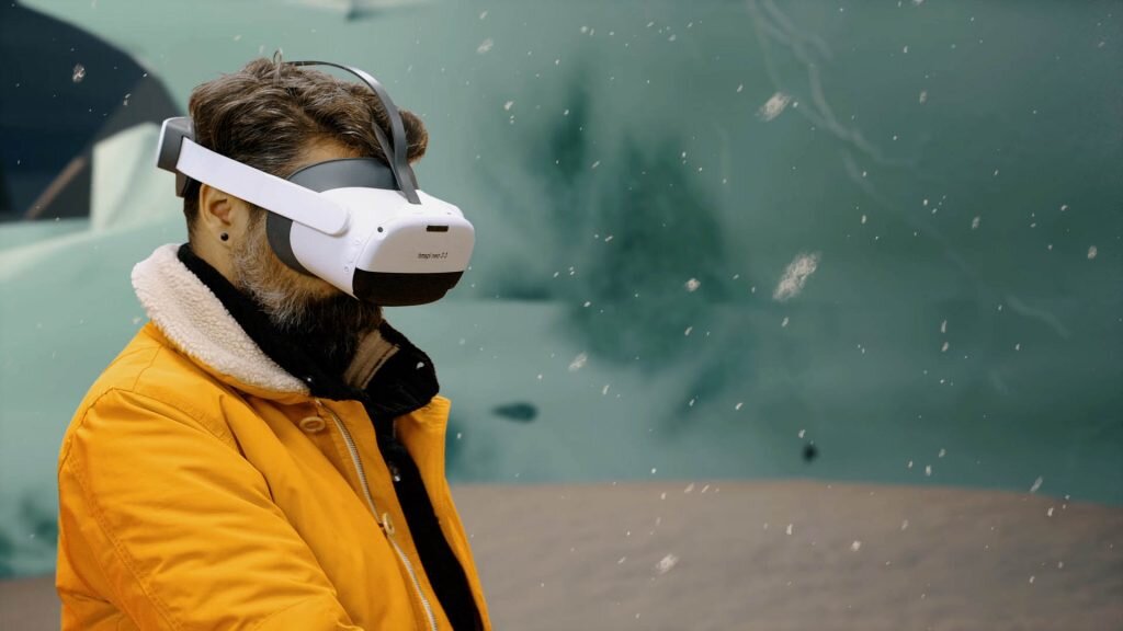 Person trägt eine Virtual-Reality-Brille und Kopfhörer, vertieft in ein VR-Erlebnis