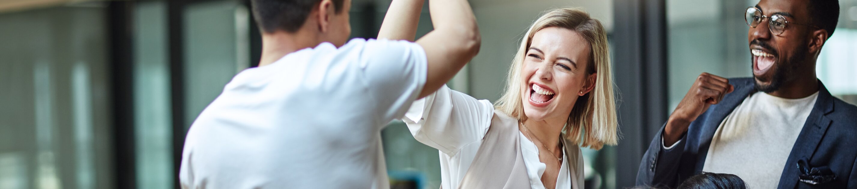 team feiert einen erfolg im büro mit high-five und begeisterten reaktionen