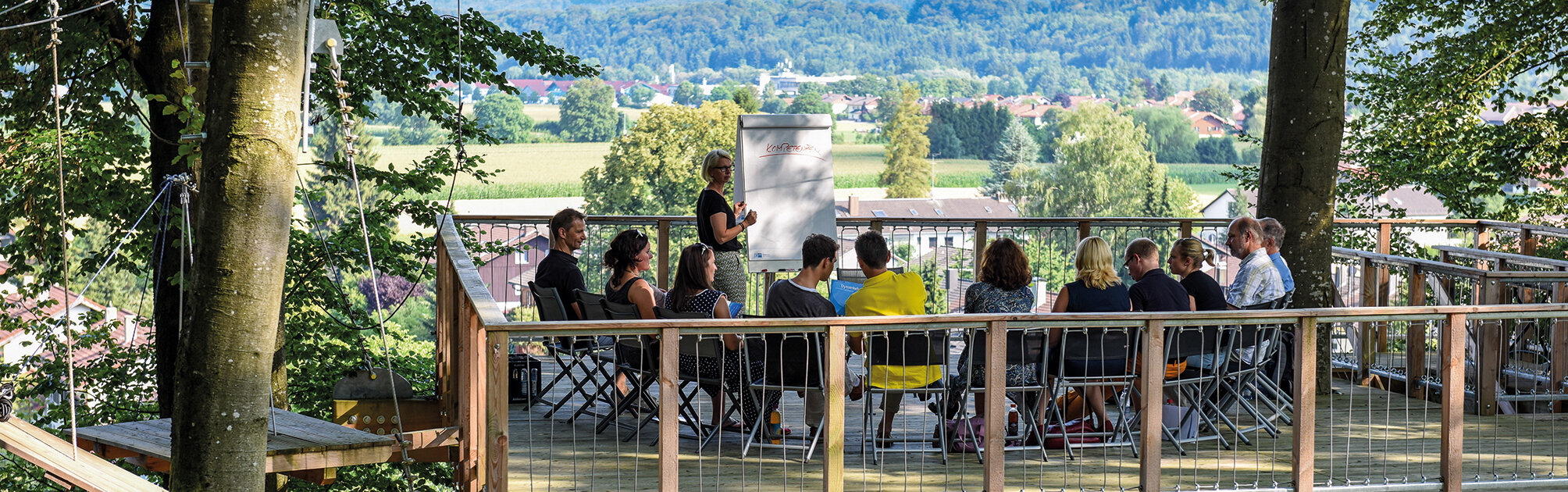seminar auf erhöhter baumplattform mit aussicht über wald und landschaft