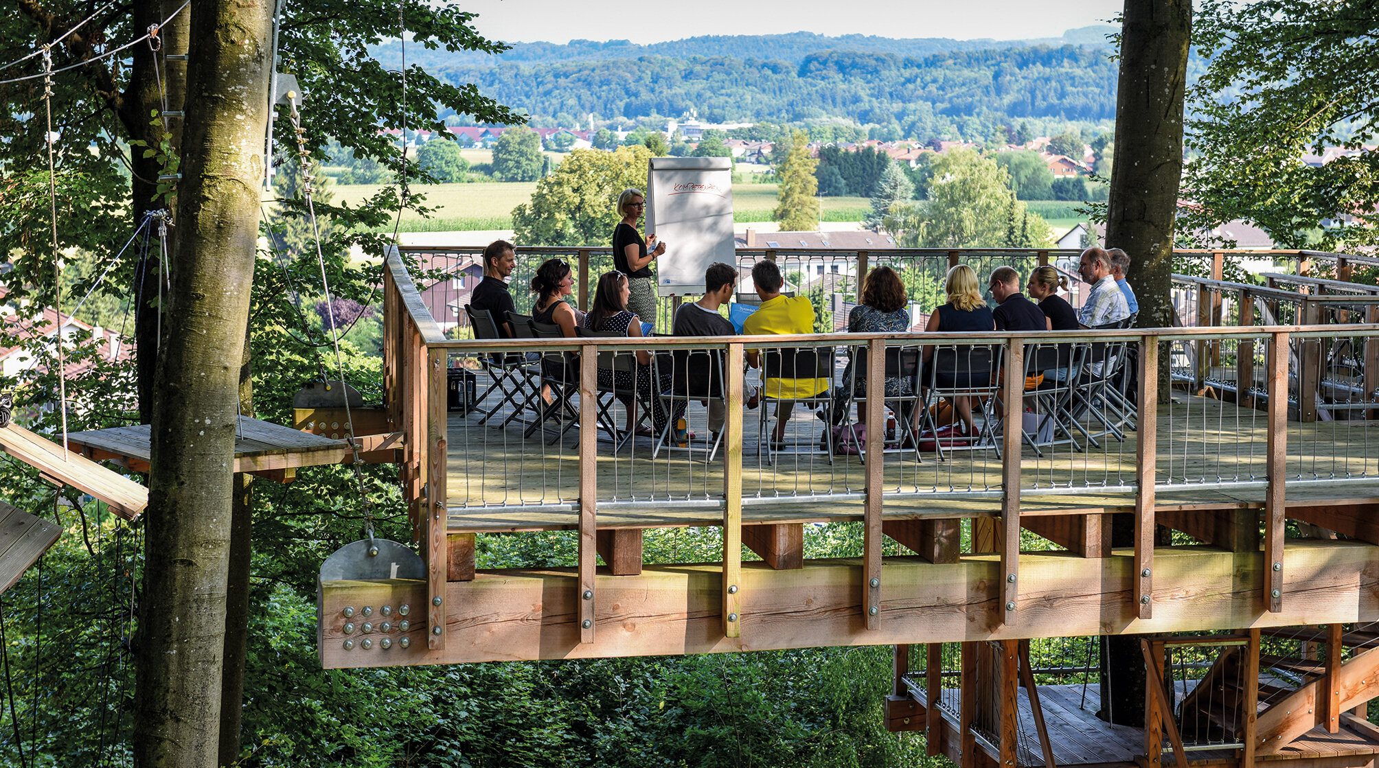 Seminar im Grünen auf einer Baumplattform – Tagung im Freien mit Blick auf die bayerische Landschaft nahe München im ausgezeichneten Tagungshotel