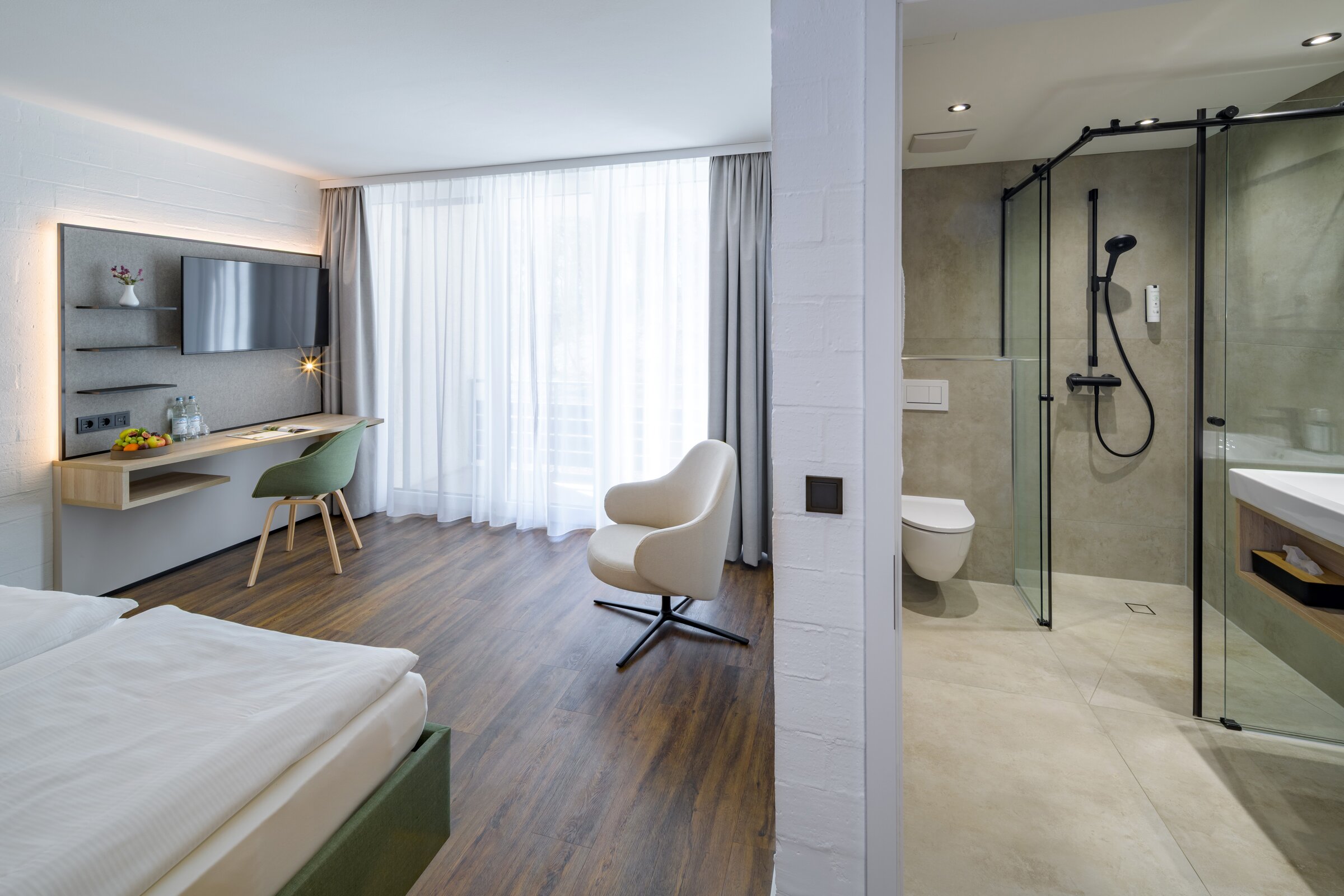 Doppelzimmer der Akademie Westerham mit hellem Wohnbereich und rollstuhlgerechtem Bad mit ebenerdiger Dusche