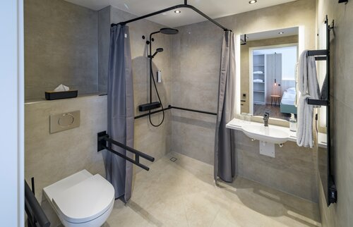 Barrierefreies Badezimmer der Akademie Westerham mit ebenerdiger Dusche, Haltegriffen und unterfahrbarem Waschbecken