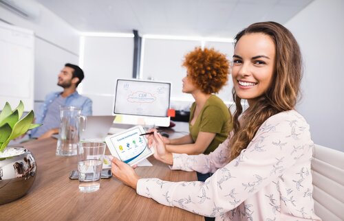 Mitarbeitende sitzen gemeinsam im modernen Büro und besprechen Projektideen – steht für Teamarbeit, Innovation und sinnstiftende Arbeit an der IHK Akademie München und Oberbayern.