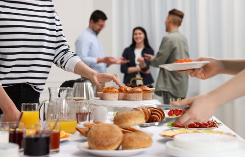 Person greift nach Brötchen und Saft am Buffet – steht für Austausch und Networking beim Ausbilderfrühstück Weilheim.