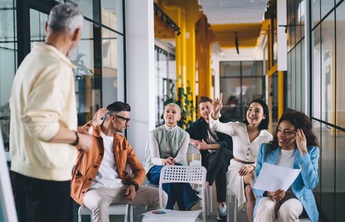 Ausbilder/-innen und Azubis kommen in einer Weiterbildung zusammen, um in einem Dialog die Zusammenarbeit in der Ausbildung zu optimieren. 