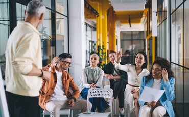 Dozent spricht vor einer Gruppe junger Menschen – steht für interaktives Lernen und pädagogische Kompetenz in der Ausbildung.