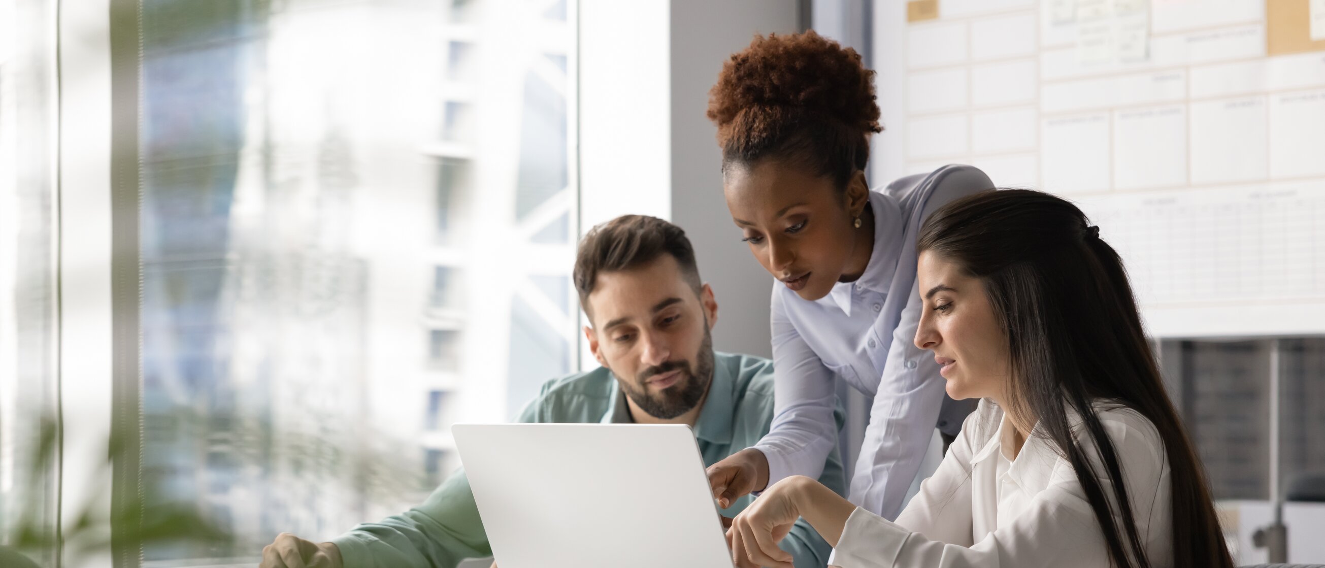 Drei Personen arbeiten gemeinsam am Laptop und besprechen Inhalte – Symbol für Ausbilderseminare, Teamarbeit und praxisnahes Lernen.