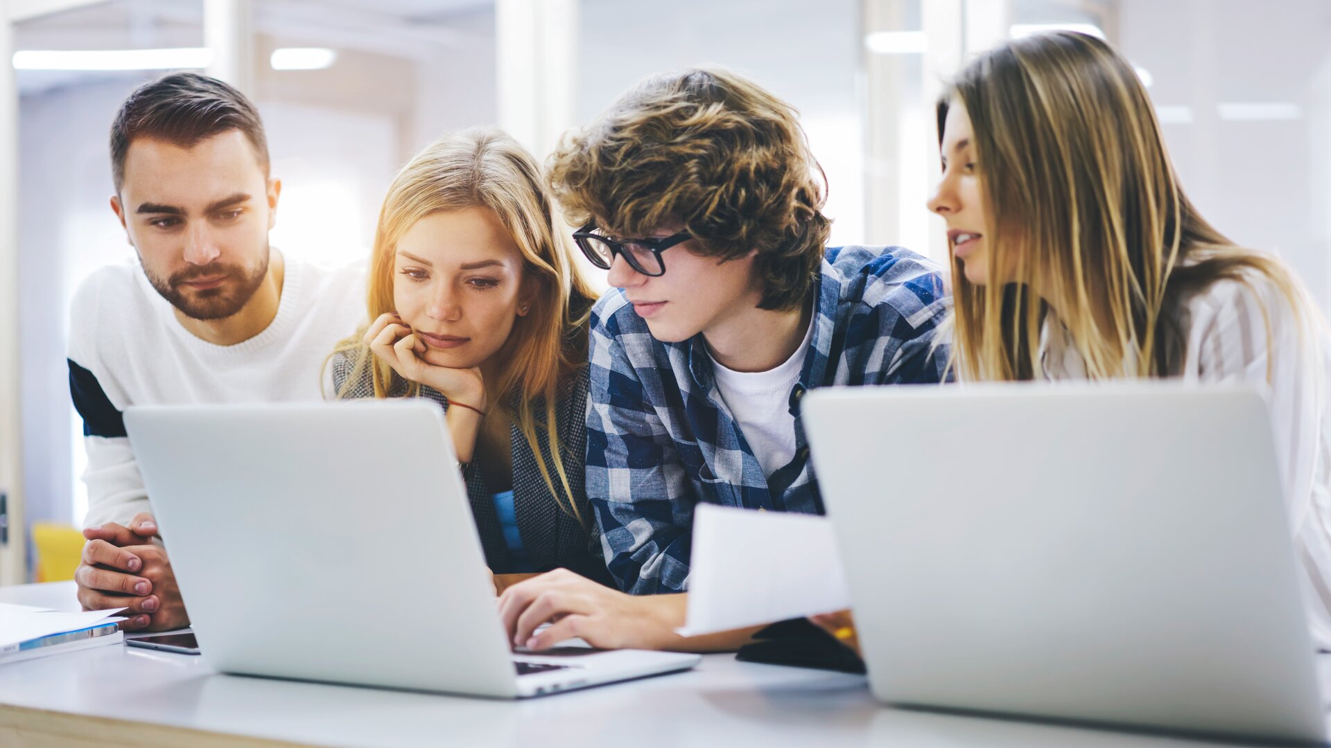 Weiterbildung für Auszubildende: Azubis sitzen in einer Gruppe vor dem Laptop