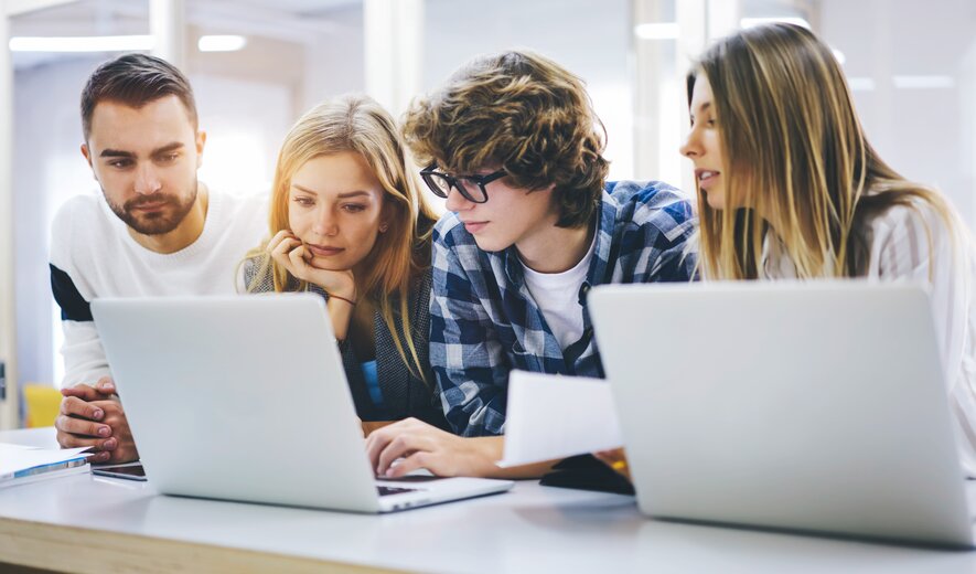 Weiterbildung für Auszubildende: Azubis sitzen in einer Gruppe vor dem Laptop