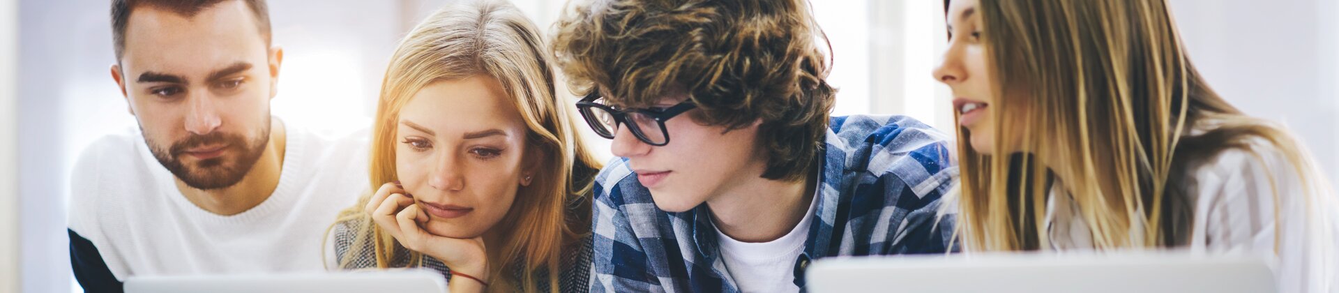 Weiterbildung für Auszubildende: Azubis sitzen in einer Gruppe vor dem Laptop