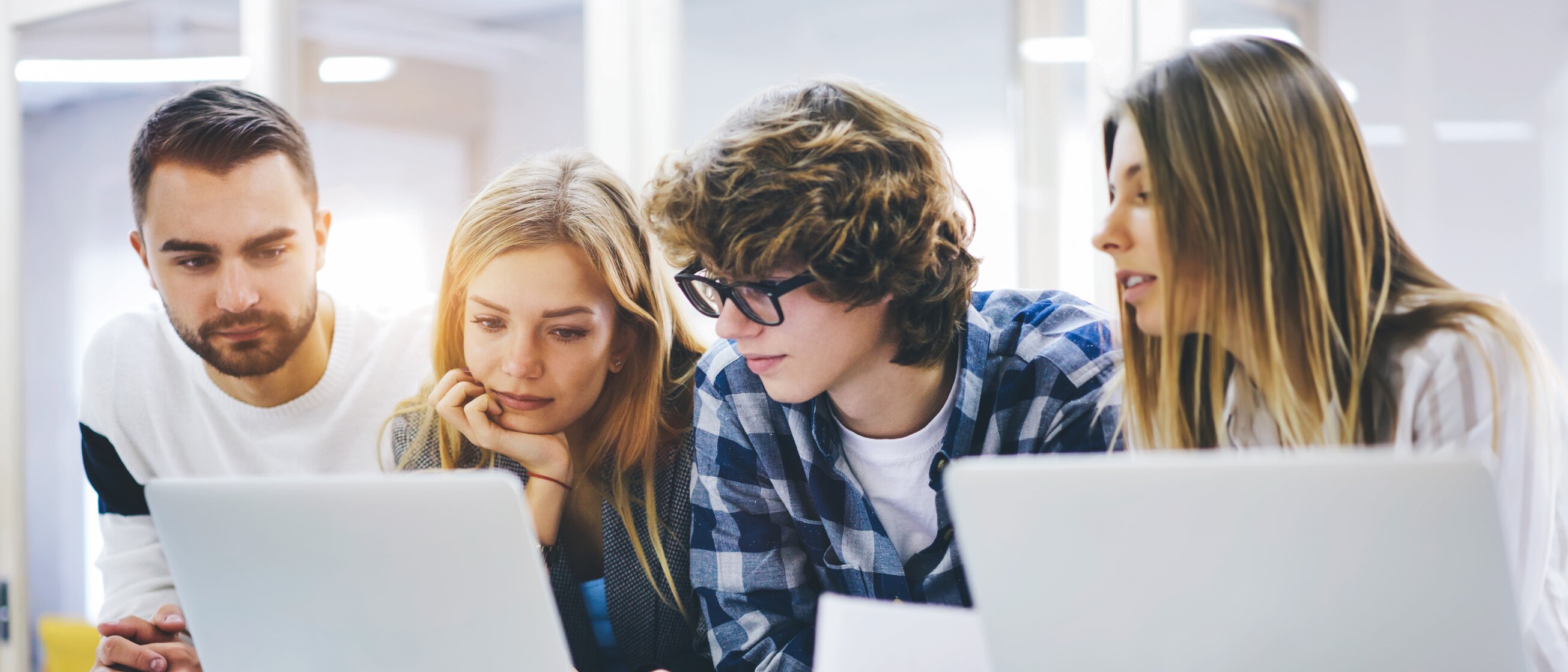 Gruppe junger Menschen arbeitet gemeinsam an Laptops – Symbol für engagierte Auszubildende in der Weiterbildung und Teamarbeit im Berufseinstieg.