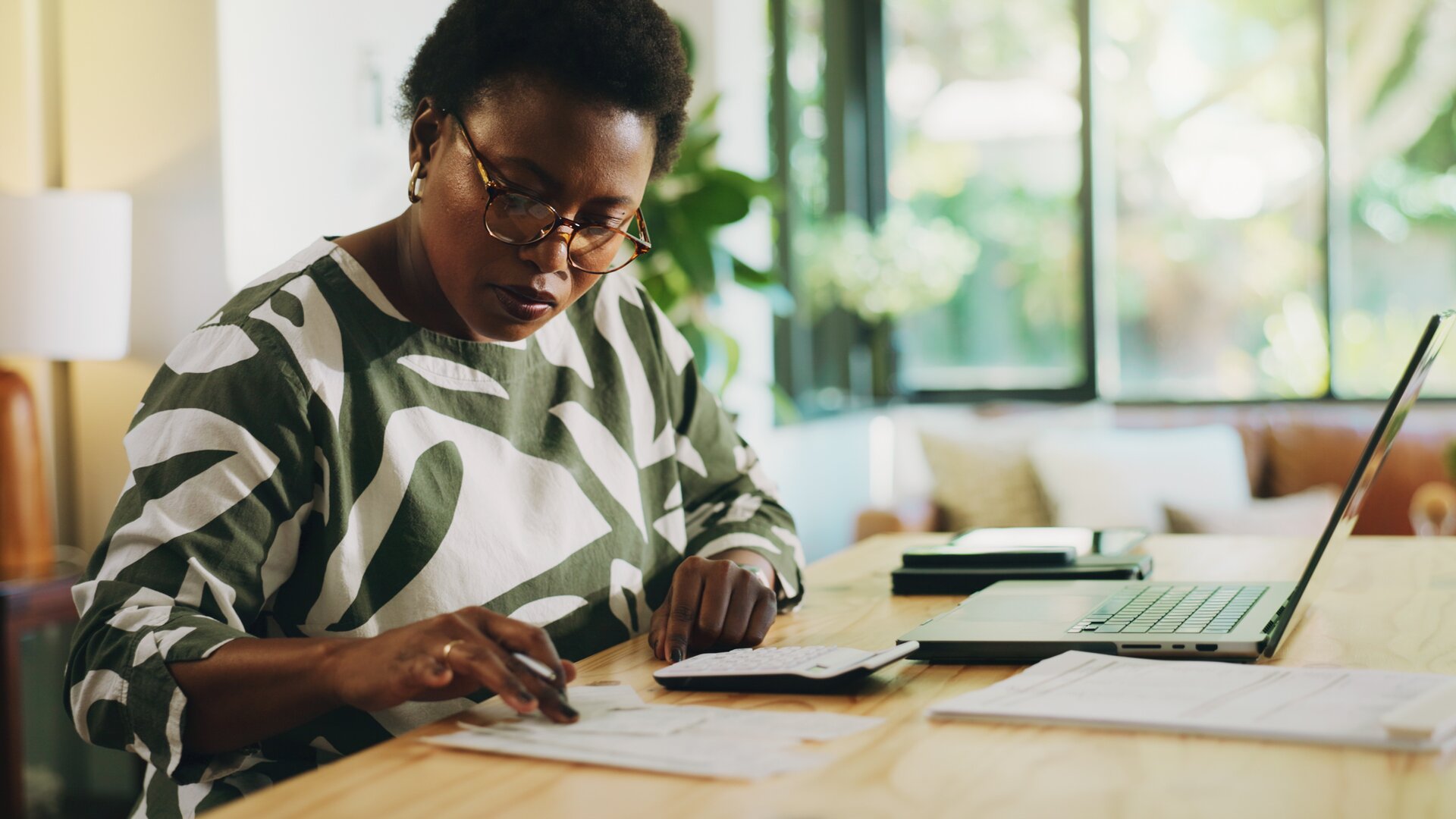 Eine Frau präsentiert ihrem Team Geschäftsgrafiken auf einem großen Bildschirm.